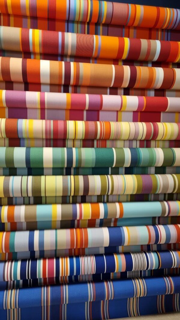 Interior de Les Toiles du Soleil con telas de rayas catalanas de colores vivos en Perpignan