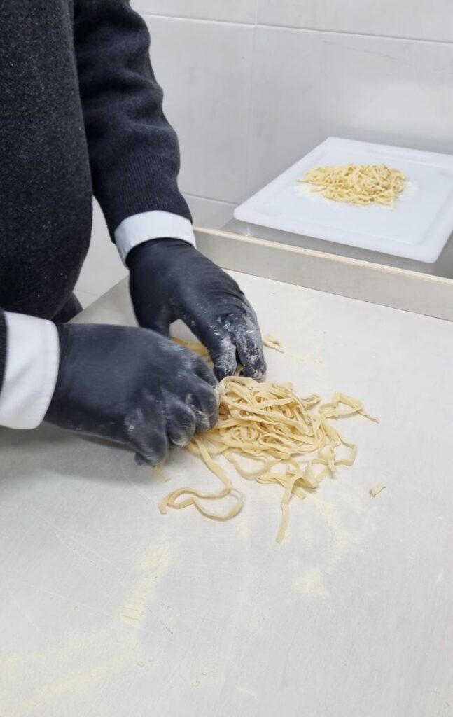Preparación de pasta fresca artesanal durante el taller culinario en Rotonda, Basilicata