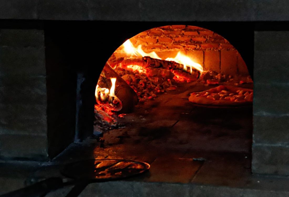 Pizza en horno de leña durante taller práctico en Basilicata, Italia