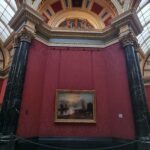 Interior del hall central de la National Gallery de Londres con su cúpula decorada, columnas de mármol negro y suelo geométrico