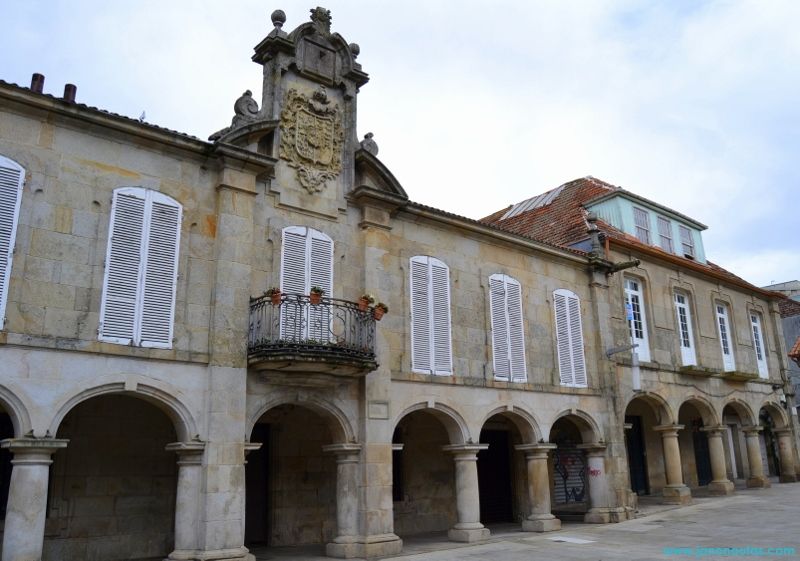 Fachada del Pazo de Mugartegui en Pontevedra, edificio barroco del siglo XVII con soportales, escudos nobiliarios y reloj de sol.