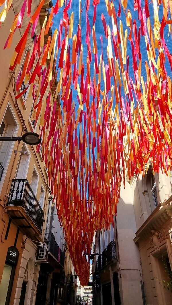 Calle del centro histórico de Perpignan decorada con cintas de colores