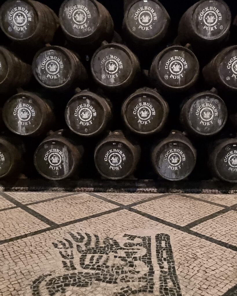 Mosaico de adoquines portugueses con el logo de Cockburn's en el suelo de la galería de envejecimiento