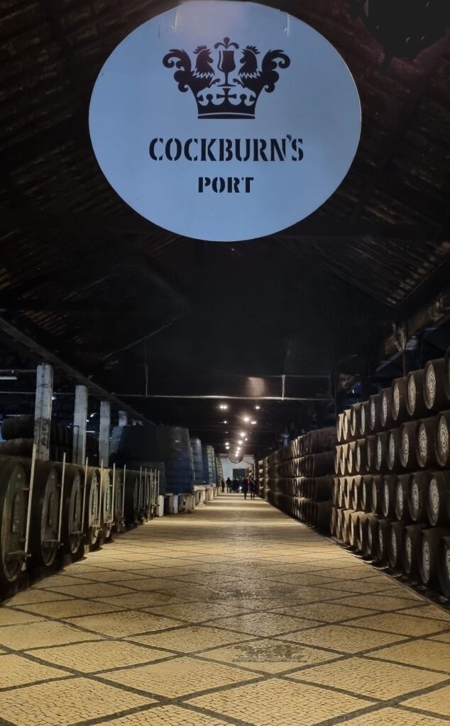 Cartel de Cockburn's Port colgando sobre la galería de barricas en las Bodegas Cockburn's de Oporto