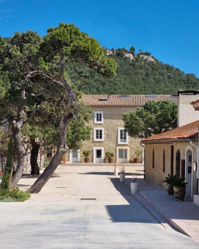 Edificio principal del Château l'Hospitalet entre pinos y vegetación mediterránea