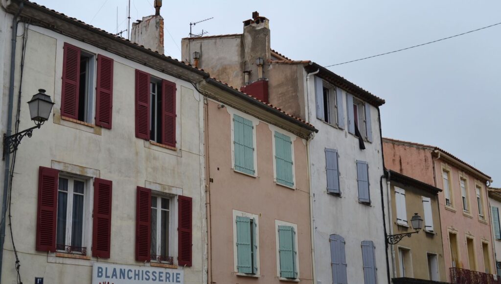 Fachadas de colores mediterráneos con contraventanas en el centro histórico de Narbonne