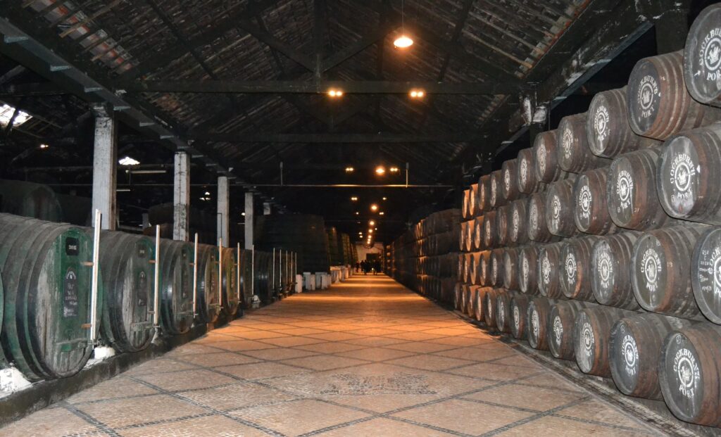 Vista general de la galería de envejecimiento de las Bodegas Cockburn's con miles de barricas a ambos lados en Vila Nova de Gaia