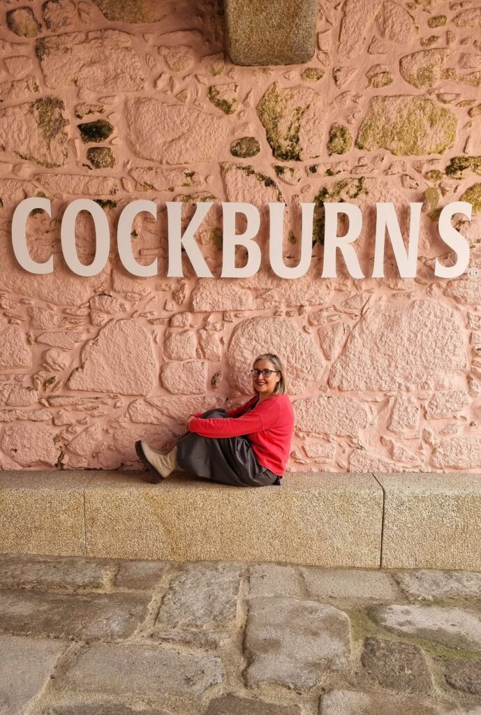 Janonauta posando ante el letrero de Cockburn's en la pared rosa de las Bodegas Cockburn's de Oporto