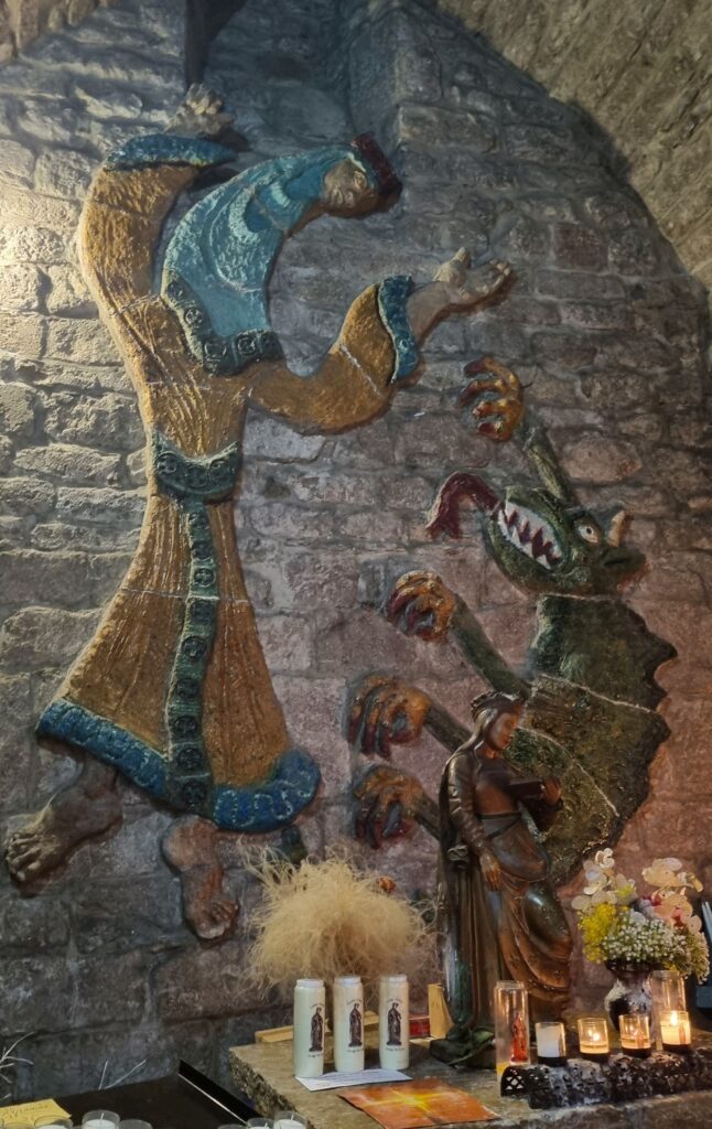 Relieve de cerámica de la leyenda de Santa Enimia y la bestia en la iglesia de Sainte-Énimie