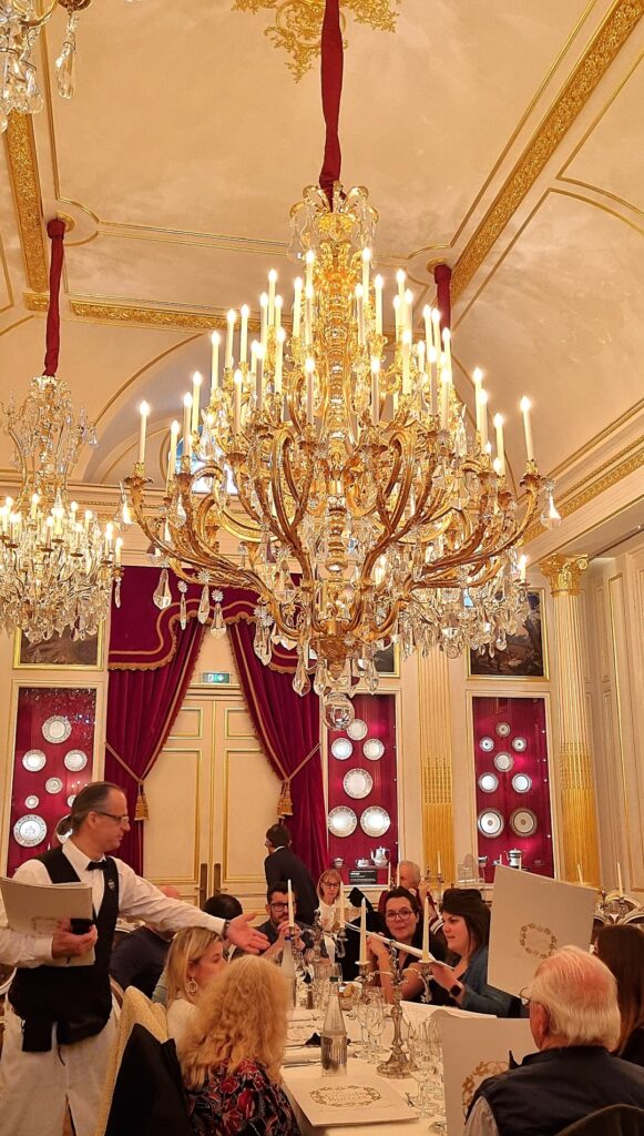 Elegante sala interior de Les Grands Buffets de Narbonne con lámparas de araña doradas