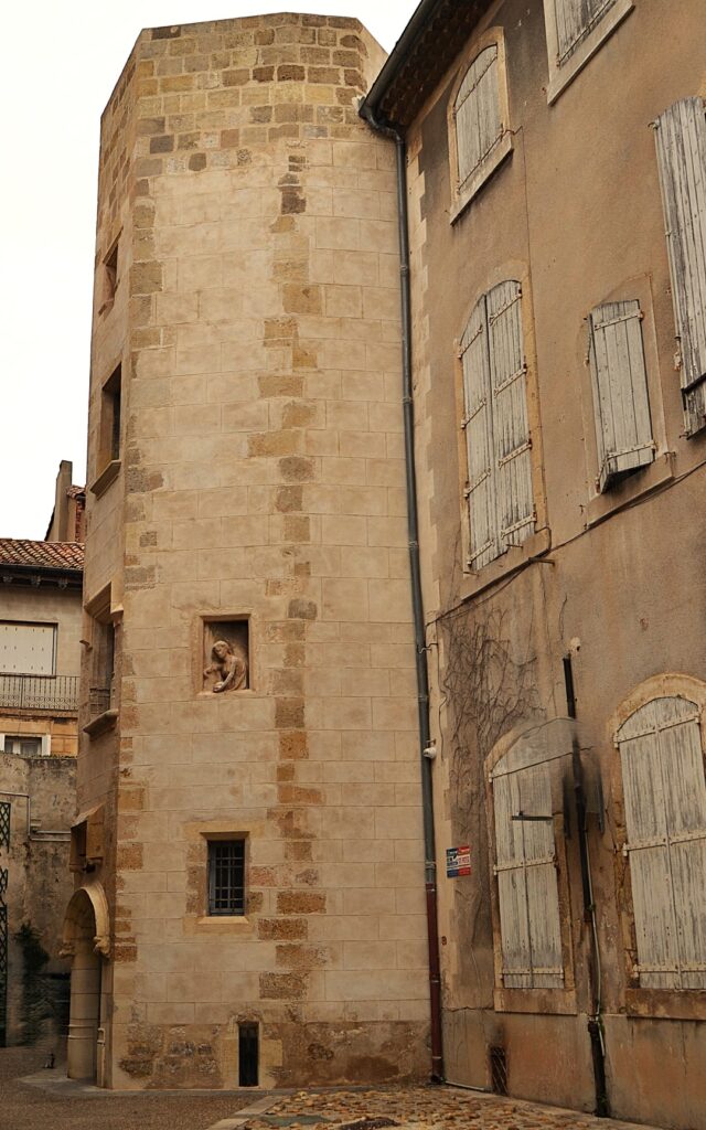Torre medieval de sillería con hornacina escultórica en el casco antiguo de Narbonne